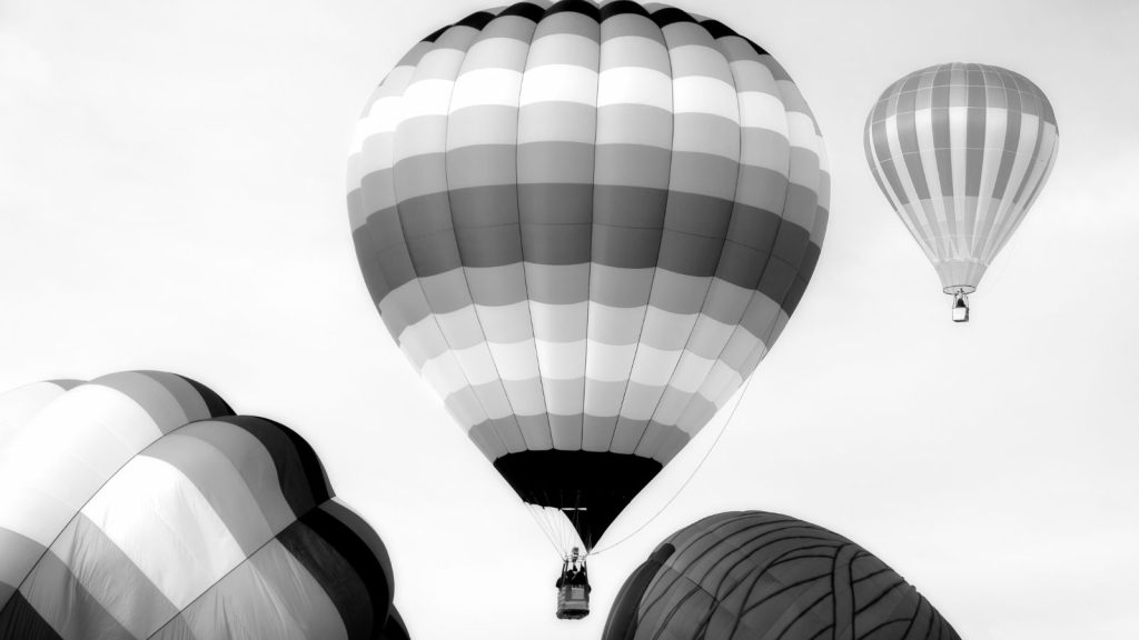 Black and white photo of hot air balloons inflating and rising