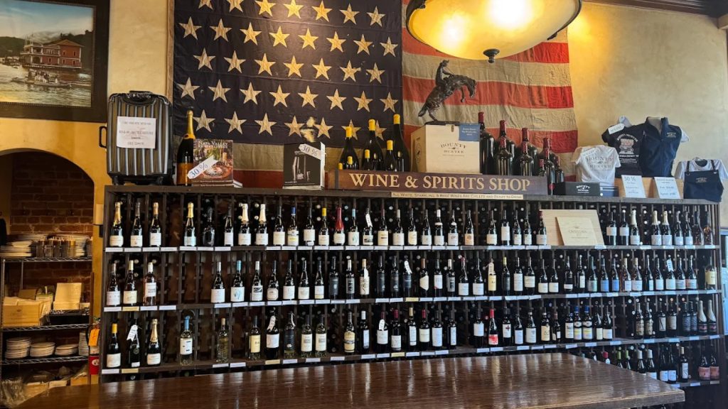 Bounty Hunter Wine Bar & Smokin' BBQ features an extensive wine and spirits shop with hundreds of bottles displayed, patriotic décor, and a wooden tasting counter.