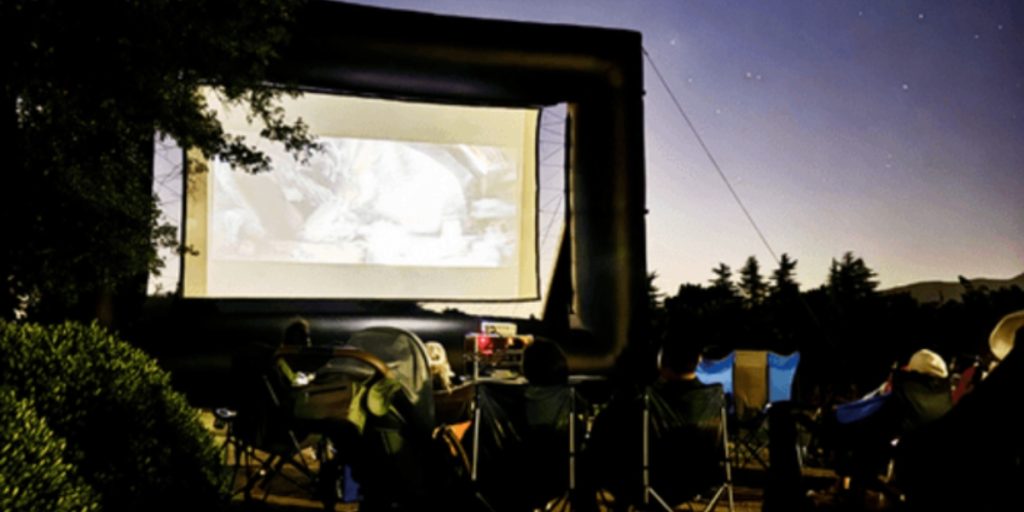 Napa in August - Summer Series Movie Night: an outdoor movie screening under the stars with audiences in lawn chairs watching a film projected on an inflatable screen.