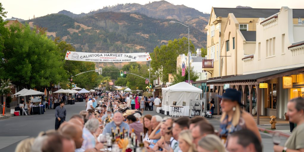 Calistoga Harvest Table – outdoor street festival event with crowds of visitors, vendor tents, and local restaurants celebrating wine harvest season in downtown Calistoga with mountain backdrop