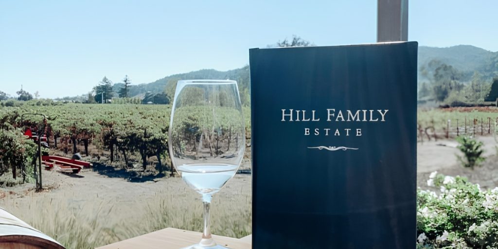 Napa Valley Winery During Harvest Hill Family Estate – elegant wine glass with scenic vineyard backdrop, rolling hills, and mountain views showcasing the winery's harvest season landscape