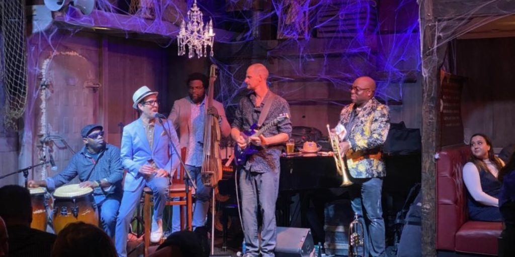 The Fink, Napa Valley's premier cocktail bar and lounge, features live jazz musicians performing on stage with purple atmospheric lighting, vintage décor, and an intimate venue setting.